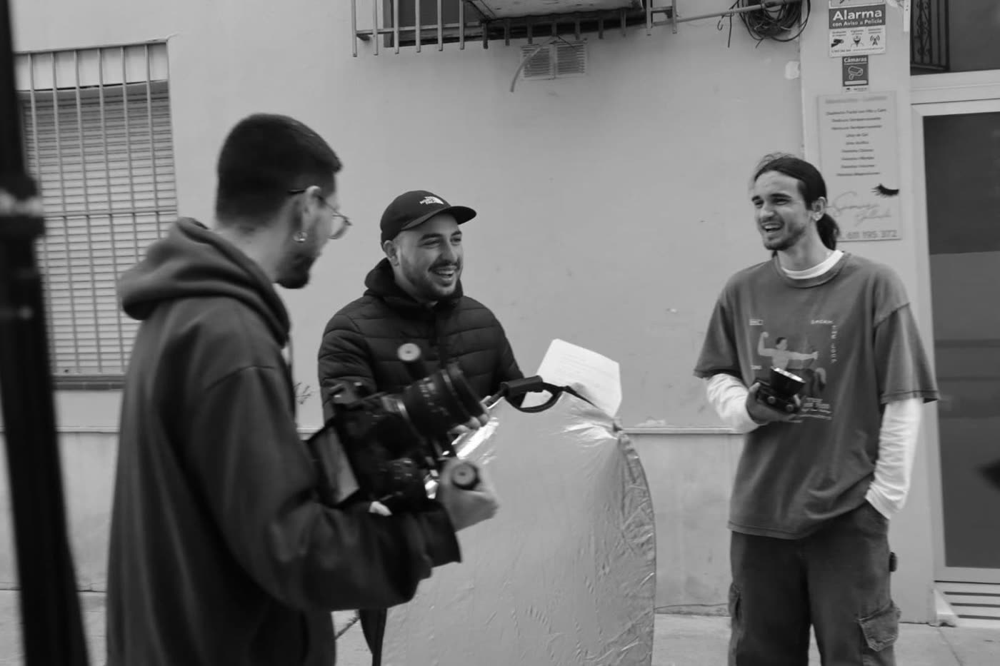 El equipo de Bululú Studio riendo durante un rodaje en la calle, con cámara de cine y reflector