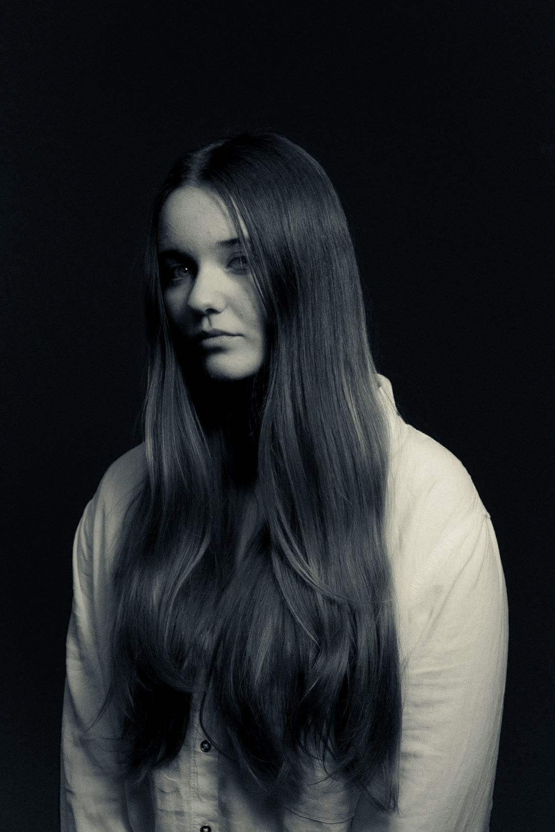 Retrato en estudio de una chica de pelo largo sobre fondo negro